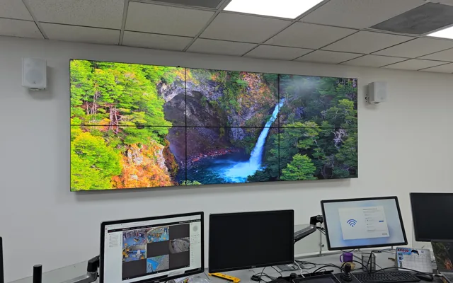 Videowall de seis pantallas instalado en una sala de monitoreo con puestos de operación